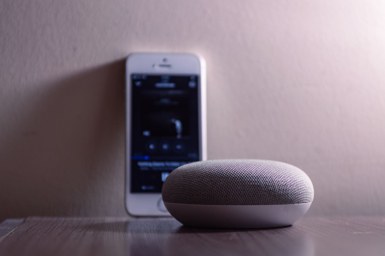 Crafting Captivating Headlines: Your awesome post title goes here A modern smart speaker and smartphone on a wooden table, indoors.